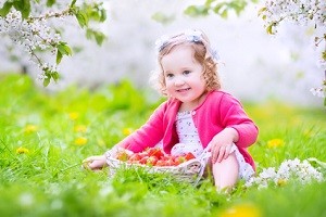 Toddler snack ideas Toddler girl eating strawberry in blooming garden