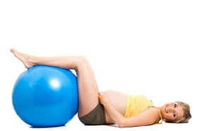 Pregnant woman with gymnastic ball isolated on white