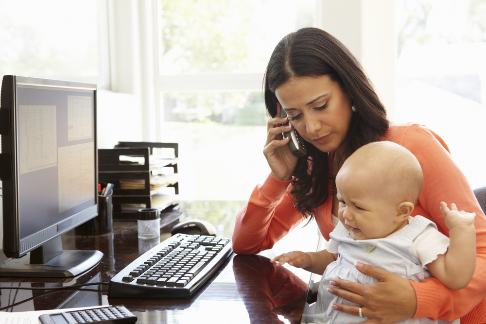 Mother working from home with a baby on her lap